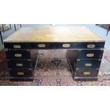 A 20th century brass bound ebonised pedestal desk of Campaign design with nine drawers about the