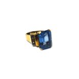 A gold ring, claw set with a cut cornered rectangular step cut synthetic blue spinel at the centre,