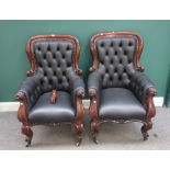 A pair of Victorian mahogany framed armchairs, with buttoned black leather upholstery,