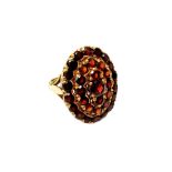 A 9ct gold and garnet set oval cluster ring, mounted with circular cut garnets, London 1962,