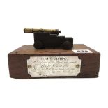 A brass and oak mounted model cannon set on timber from HMS Victory,