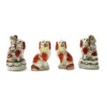 A pair of Staffordshire spaniels, 19th century, each with russet markings,