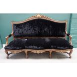 An 18th century style Italian parcel gilt carved walnut open arm sofa,