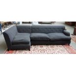 A 20th century charcoal grey upholstered corner sofa, on tapering block supports,