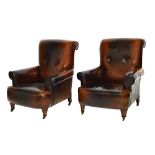A pair of early 20th century brass studded brown leather upholstered easy armchairs,