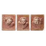 A set of three 18th/19th century carved pine and gesso plaques of winged cherubs,
