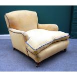 A Howard style early 20th century easy armchair, with deep seat, on tapering square supports,