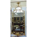 An 18th century style gilt framed wall mirror, with urn crest about the shaped segmented frame,