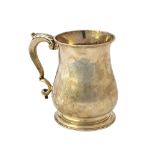 A George II silver mug, of baluster form, having a scrolling handle, crest engraved,