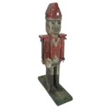 A polychrome painted wood folk art figure, two sided, modelled as a soldier on a plank base,