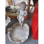 A lead figural bird bath, 20th century modelled with a putto figure over a shell form bowl,