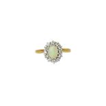 An 18ct gold, opal and diamond oval cluster ring, claw set with the oval opal at the centre,