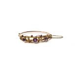 A 9ct gold, amethyst and seed pearl set oval hinged bangle,