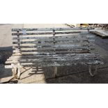 An early 20th century white painted wrought iron garden bench, with slatted seat,