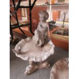 A lead figural bird bath, 20th century, modelled with a putto figure over a shell bowl,