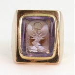 An amethyst intaglio signet ring, the rectangular intaglio carved with a letter 'J' and crest,