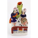 A Staffordshire pottery group of two children in highland clothes, a dog between them,