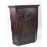 A George III oak wall hanging corner cabinet,