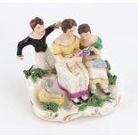 An English porcelain group, circa 1830, modelled as a mother holding an open book,