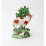 An English pearl glazed earthenware figure of a sheep and lamb in bocage,