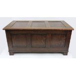 A reproduction oak coffer, in 17th century style, of panelled construction with hinged top,