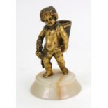 A French gilt metal match holder, late 19th century, in the form of a bacchanalian putti,