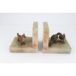 A pair of green onyx book ends, circa 1930, each mounted with a cold painted bronze animal,