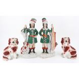 A pair of Staffordshire pottery figures of huntsman wearing plumed hats,