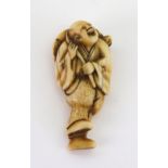 A ivory netsuke, probably 18th century, carved as a fisherman carrying a turtle across his back, 5.