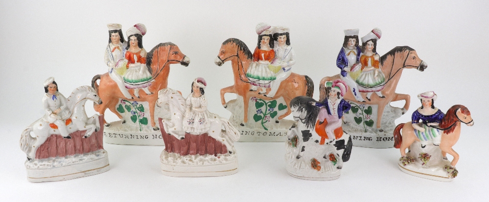 A pair of Staffordshire pottery figures of a boy and girl on horseback jumping fences, 16cm high,