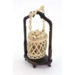 A Canton ivory basket, late 19th century, the lattice pierced sides enclosing numerous figures,