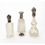 Three Dutch silver mounted cut and moulded glass perfume bottles, 19th century, of varying shapes,