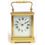 A brass cased carriage clock, early 20th century, the white enamel dial with Roman numerals,
