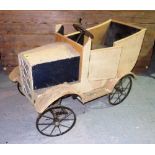 A vintage child's wooden toy pedal car.