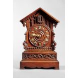 A Tyrolean walnut fusée cuckoo clock Circa 1890 The case in the form of a chalet with arched