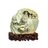 A Chinese jade boulder carving, of pale celadon tone with light brown and cream inclusions,