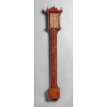 A late George II walnut stick barometer The arched pediment surmounted by three brass finials,