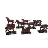 A set of eight Chinese carved wooden horses of Mu Wang, early 20th century, in varying poses,