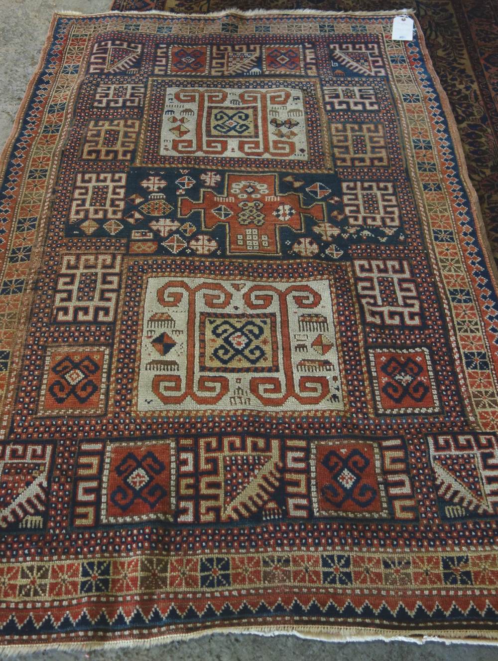 A Karachor Kazak rug, Caucasian, the indigo field with two ivory squares, a madder central cross,