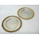 A pair of silver and gilt shallow dishes, each of shaped circular form,