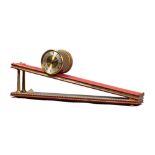 A brass, red perspex and leather-lined inclined plane timepiece Dent, London, by Andrew Fell,