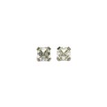 A pair of platinum and diamond single stone ear studs, each claw set with an emerald cut diamond,