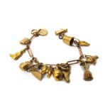 A 9ct gold bar and oval link bracelet, fitted with fifteen mostly 9ct gold charms,