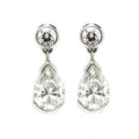 A pair of 18ct white gold and diamond two stone pendant earrings,