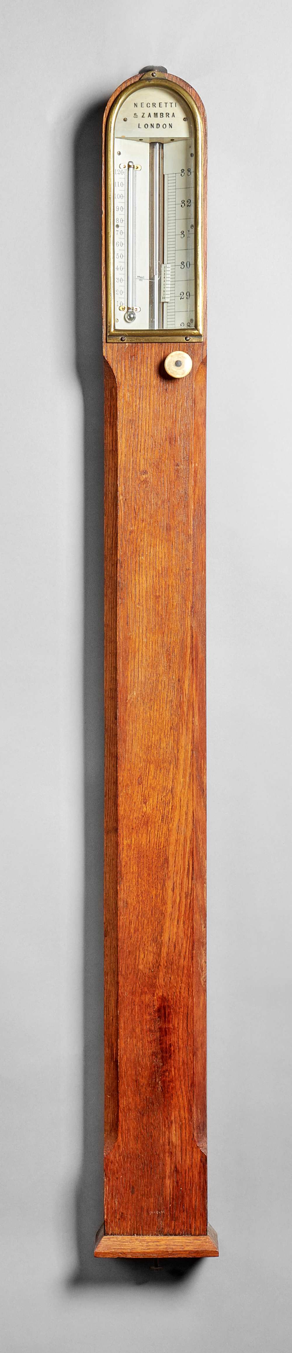 A late Victorian oak and brass-mounted stick barometer By Negretti & Zambra, London,