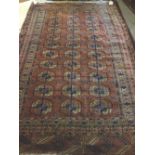 A Tekke Turkman rug, the madder field with three columns of eleven guls, supporting bee crosses,