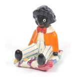 A Clarice Cliff Bizarre 'Autumn Blue' pattern seated Golliwogg bookend, printed marks, 15.5cm.