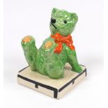 A Clarice Cliff Teddy Bear bookend, the green up-ended teddy with orange ribbon on a square base,