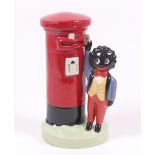 A Carlton Ware figure 'Golliwogg posts a letter', probably after a design by Francis Joseph,