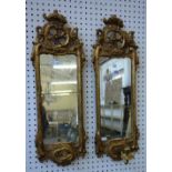 A pair of 18th century Continental gilt framed girandole wall mirrors with pierced and carved